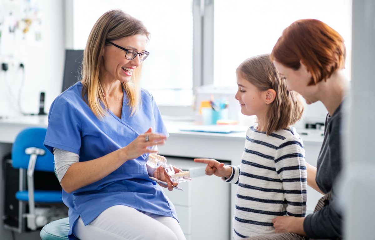 A small girl, mother and dentist in surgery, dental checkup